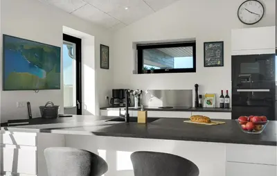 a kitchen with a counter with chairs and a table at Beautiful Home In Thisted With Sauna in Thisted
