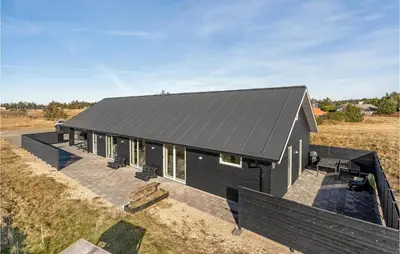 a black house with a black roof on a field at Beautiful Home In Thisted With Sauna in Thisted
