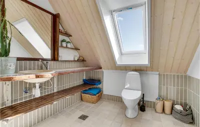 a bathroom with a toilet and a sink and a window at Gorgeous Home In Øster Assels in Øster Assels