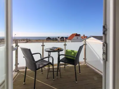 a balcony with chairs and a table with a view of the ocean at Holiday Home Ena - 75m from the sea by Interhome in Lemvig