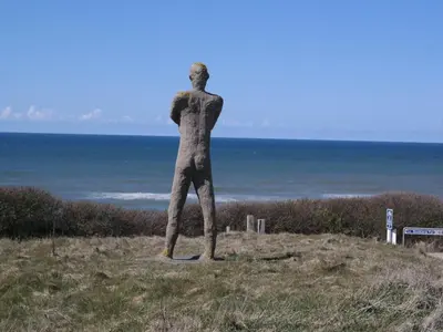 a statue of a man standing on a hill overlooking the ocean at Holiday Home Ena - 75m from the sea by Interhome in Lemvig