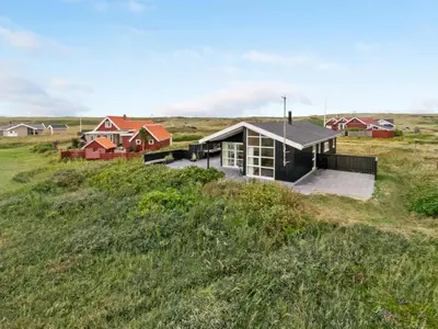 a house in the middle of a grassy field at Holiday Home Arni - 150m from the sea by Interhome in Lemvig