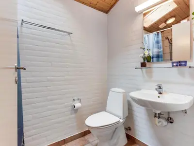 a white bathroom with a toilet and a sink at Holiday Home Arni - 150m from the sea by Interhome in Lemvig