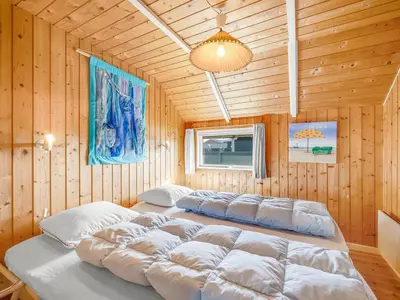 a bedroom with two beds in a wooden room at Holiday Home Sofie - 150m from the sea by Interhome in Lemvig