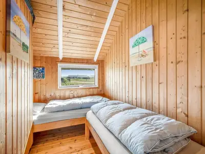 a bed in a wooden cabin with a window at Holiday Home Sofie - 150m from the sea by Interhome in Lemvig
