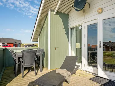a patio with chairs and a table on a deck at Holiday Home Sofie - 150m from the sea by Interhome in Lemvig