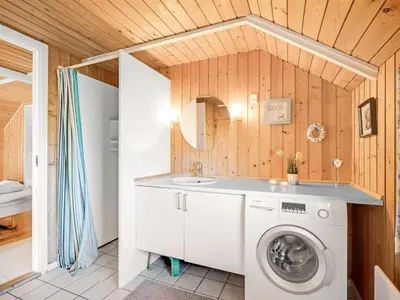 a bathroom with a washing machine and a sink at Holiday Home Sofie - 150m from the sea by Interhome in Lemvig