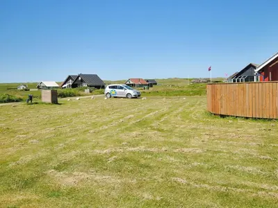 a car parked in a field next to houses at Holiday Home Beatrice - 150m from the sea by Interhome in Lemvig