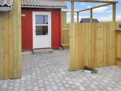 a red building with a white door and a fence at Holiday Home Beatrice - 150m from the sea by Interhome in Lemvig