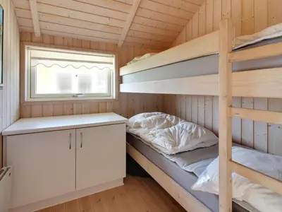 a bunk bed and a desk in a tiny house at Holiday Home Egidia - 50m from the sea by Interhome in Lemvig