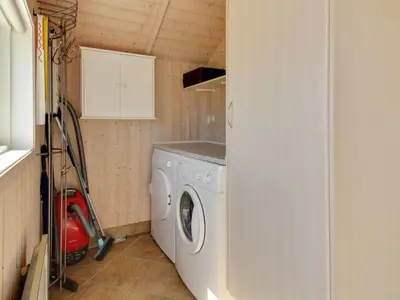 a small laundry room with a washing machine in it at Holiday Home Egidia - 50m from the sea by Interhome in Lemvig