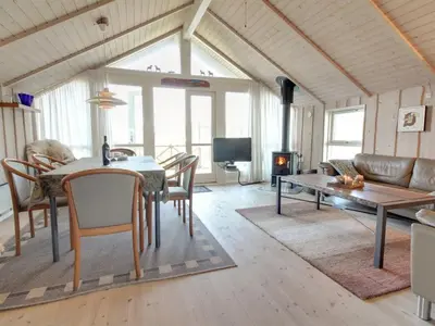 a living room with a table and a couch at Holiday Home Egidia - 50m from the sea by Interhome in Lemvig