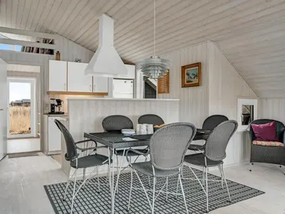 a dining room with a black table and chairs at Holiday Home Galmand - 300m from the sea by Interhome in Lemvig