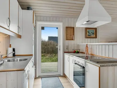 a kitchen with a door leading to a patio at Holiday Home Galmand - 300m from the sea by Interhome in Lemvig