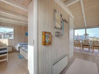 a room with a wooden wall with a mirror and a table at Holiday Home Rajna - 95m to the fjord by Interhome in Lemvig