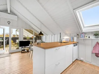 a kitchen with white cabinets and a large window at Holiday Home Kamile - 400m from the sea by Interhome in Harboør