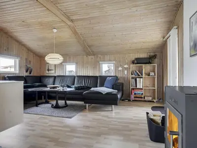 a living room with a couch and a table at Holiday Home Hebba - 300m from the sea by Interhome in Harboør
