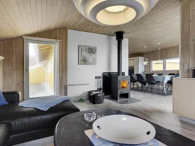 a living room with a couch and a fireplace at Holiday Home Hebba - 300m from the sea by Interhome in Harboør