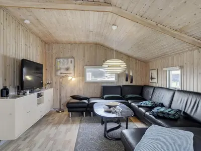 a living room with a couch and a table at Holiday Home Hebba - 300m from the sea by Interhome in Harboør