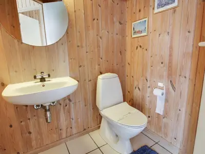 a bathroom with a white toilet and a sink at Holiday Home Suend - from the sea by Interhome in Harboør