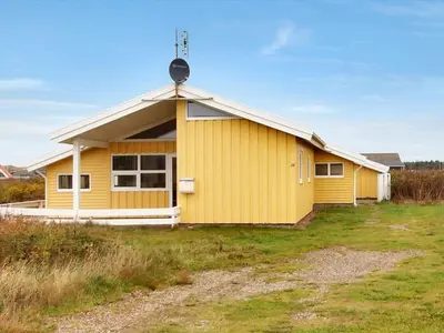 a yellow house with a antenna on top of it at Holiday Home Suend - from the sea by Interhome in Harboør