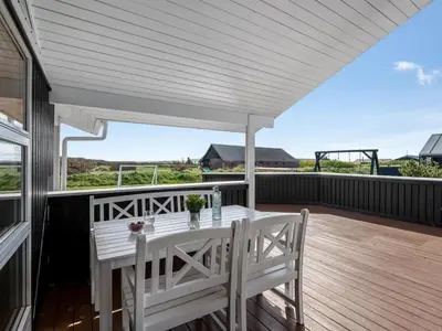a patio with a white table and chairs on a deck at Holiday Home Floriana - 650m from the sea by Interhome in Harboør
