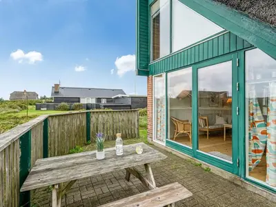 a picnic table on the deck of a house at Holiday Home Balthasar - 200m from the sea by Interhome in Harboør