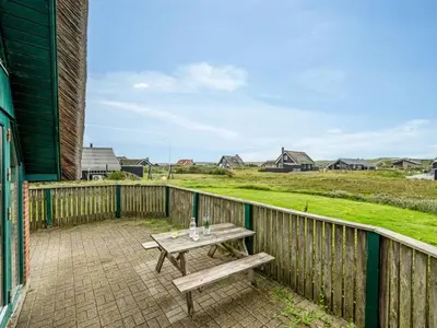 a picnic table on the balcony of a house at Holiday Home Balthasar - 200m from the sea by Interhome in Harboør