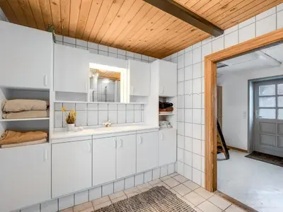 a bathroom with a sink and a mirror at Holiday Home Orvo - 150m from the sea by Interhome in Harboør