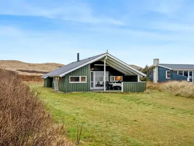 a green house on the side of a field at Holiday Home Mimo - 150m from the sea by Interhome in Harboør
