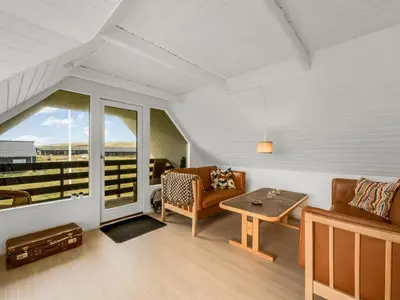 a living room with a couch and a table at Holiday Home Eringisl - 50m from the sea by Interhome in Harboør