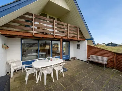 a patio with a white table and chairs on a building at Holiday Home Eringisl - 50m from the sea by Interhome in Harboør