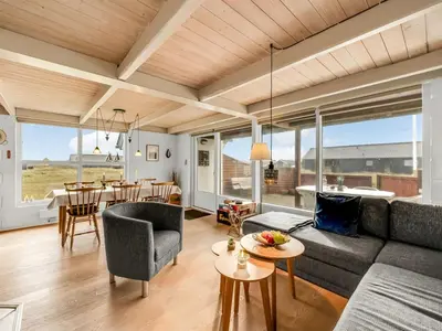 a living room with a couch and a table at Holiday Home Eringisl - 50m from the sea by Interhome in Harboør