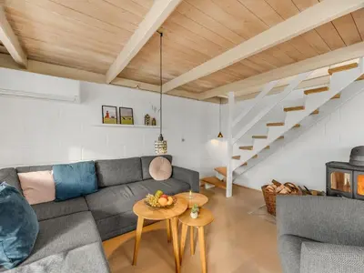 a living room with a couch and a staircase at Holiday Home Eringisl - 50m from the sea by Interhome in Harboør