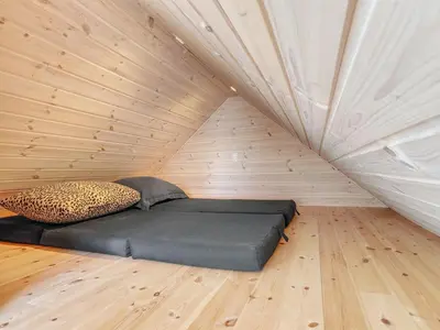 a bed in a room with a wooden floor at Holiday Home Pauli - 75m from the sea by Interhome in Harboør