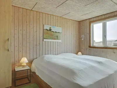 a bedroom with a white bed and a window at Holiday Home Hansen - 75m from the sea by Interhome in Harboør