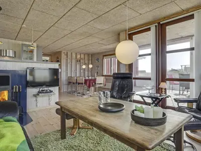 a living room with a wooden table and a television at Holiday Home Hansen - 75m from the sea by Interhome in Harboør