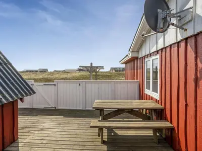 a wooden picnic table sitting on a wooden deck at Holiday Home Hansen - 75m from the sea by Interhome in Harboør
