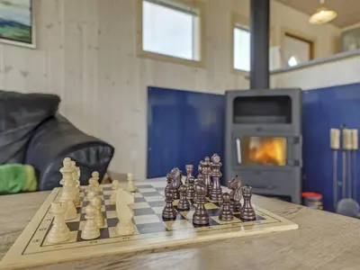 a chess board on a table in front of a fireplace at Holiday Home Hansen - 75m from the sea by Interhome in Harboør
