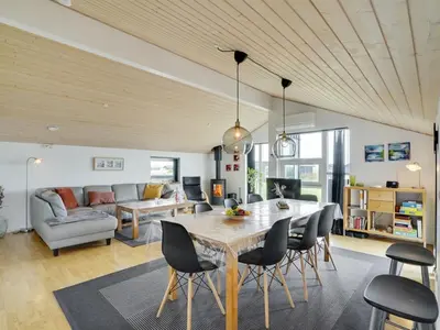 a dining room and living room with a table and chairs at Holiday Home Hildegunda - 950m from the sea by Interhome in Harboør