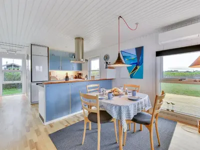 a kitchen and dining room with a table and chairs at Holiday Home Thamara - 350m from the sea by Interhome in Harboør