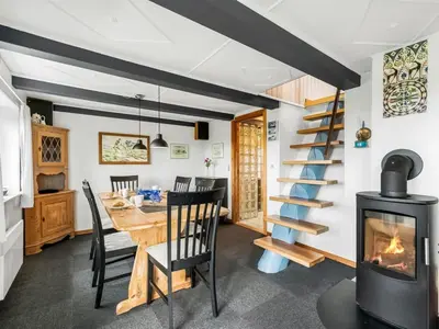 a dining room with a table and a fireplace at Holiday Home Dietlinde - 100m from the sea by Interhome in Harboør