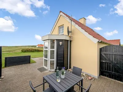 a patio with a table and chairs and a house at Holiday Home Dietlinde - 100m from the sea by Interhome in Harboør