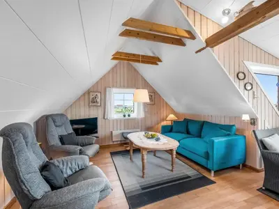 a living room with two blue chairs and a table at Holiday Home Dietlinde - 100m from the sea by Interhome in Harboør