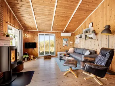 a living room with a couch and a tv at Holiday Home Brigit - 200m from the sea by Interhome in Harboør