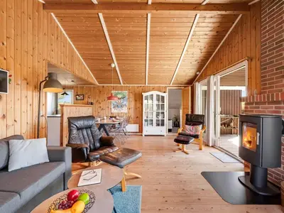 a living room with a couch and a fireplace at Holiday Home Brigit - 200m from the sea by Interhome in Harboør