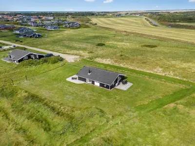 an aerial view of a house in a field at Holiday Home Eemil - 700m from the sea by Interhome in Harboør