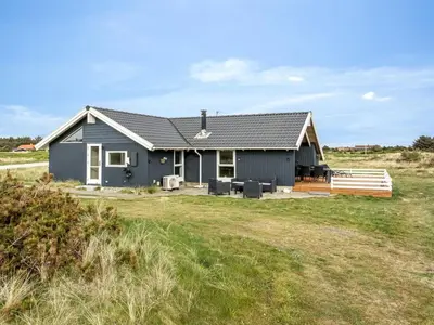 a blue house with a yard at Holiday Home Filip - 100m from the sea by Interhome in Harboør