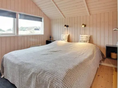 a bedroom with a large bed in a room at Holiday Home Filip - 100m from the sea by Interhome in Harboør