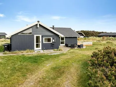 a grey house with a yard in front of it at Holiday Home Filip - 100m from the sea by Interhome in Harboør